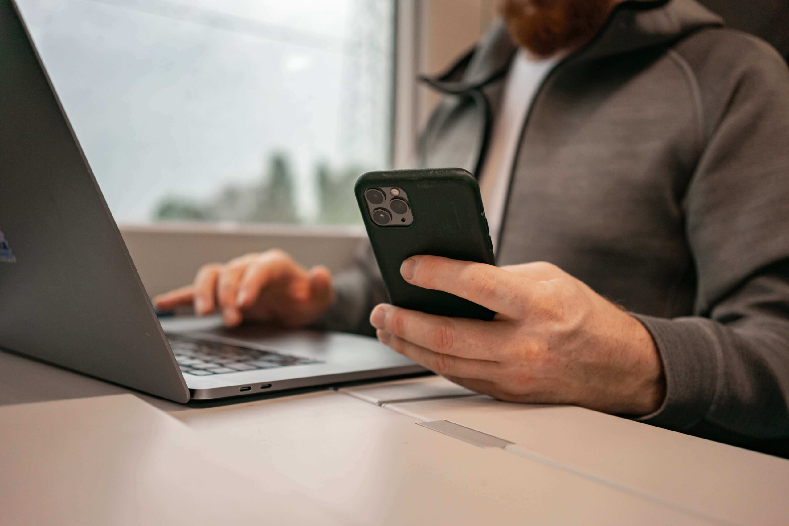 Person managing cookie consent settings on a laptop while holding a smartphone.