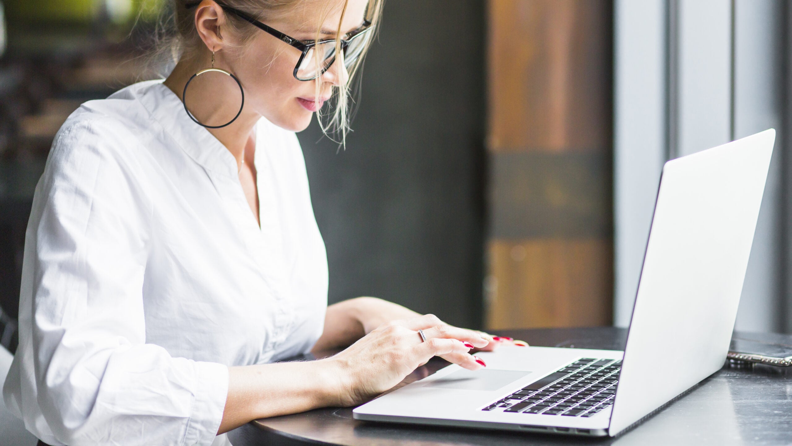 Side view of a woman working on a laptop