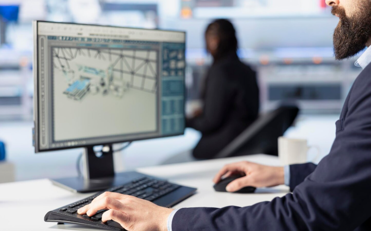 Business professional reviewing inventory software on a desktop monitor in a modern office