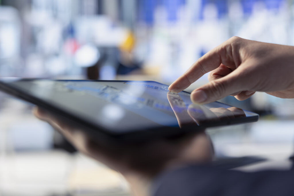 A close-up of someone using a tablet to check equipment status