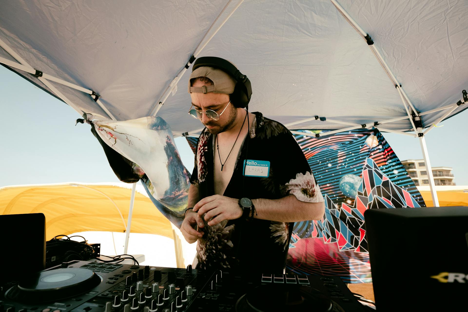 DJ with headphones mixing music outdoors at day party