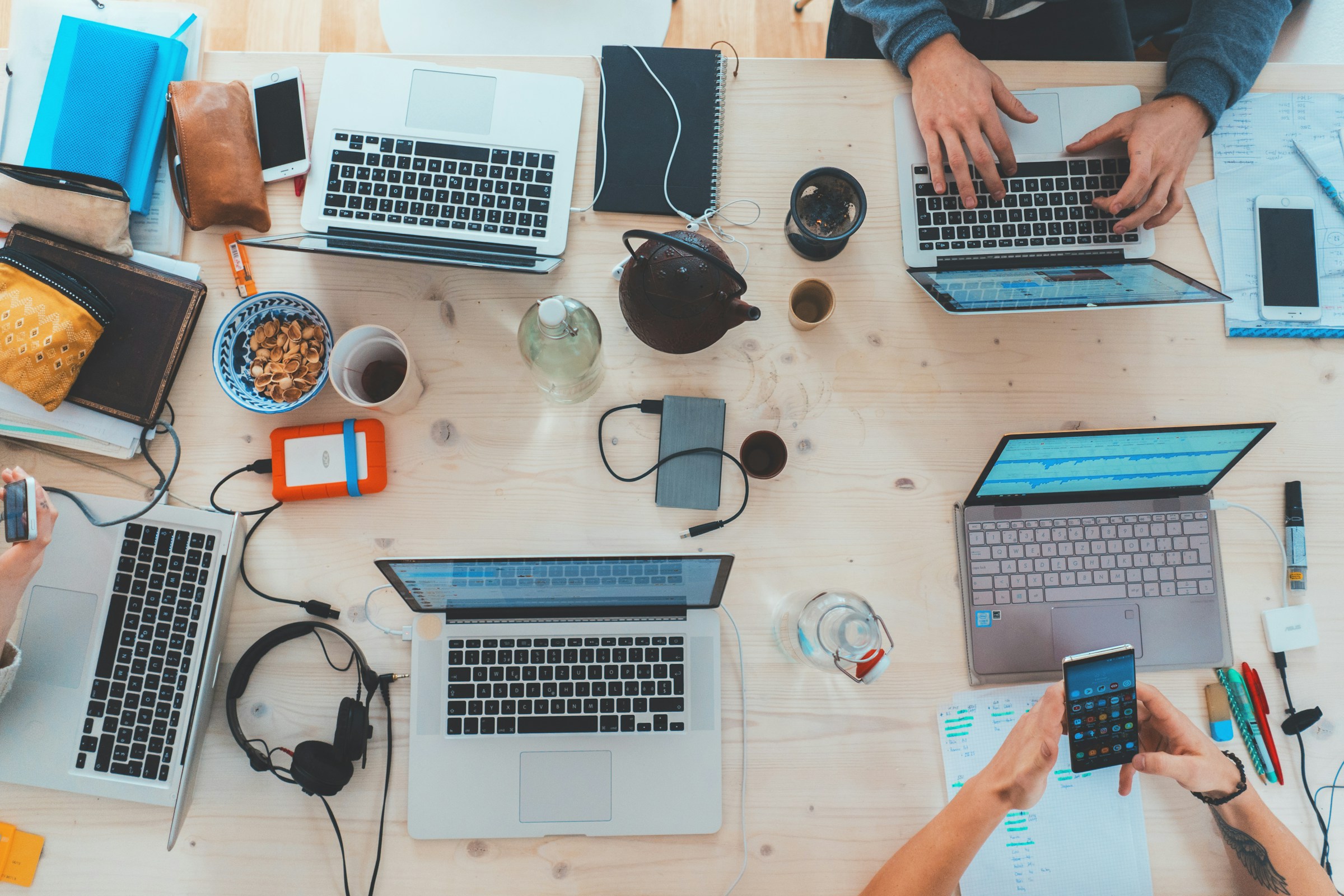 A group of employees working on a table with laptops