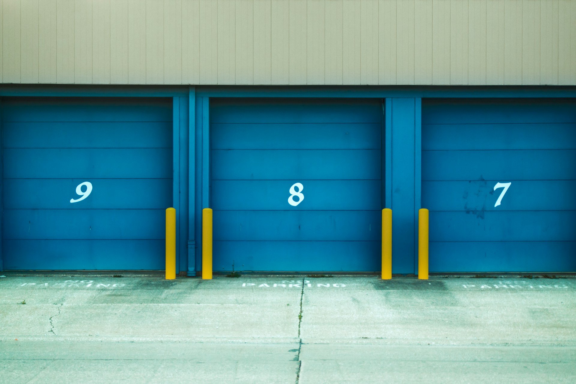 Close-up of blue garage storage units numbered seven, eight, and nine.