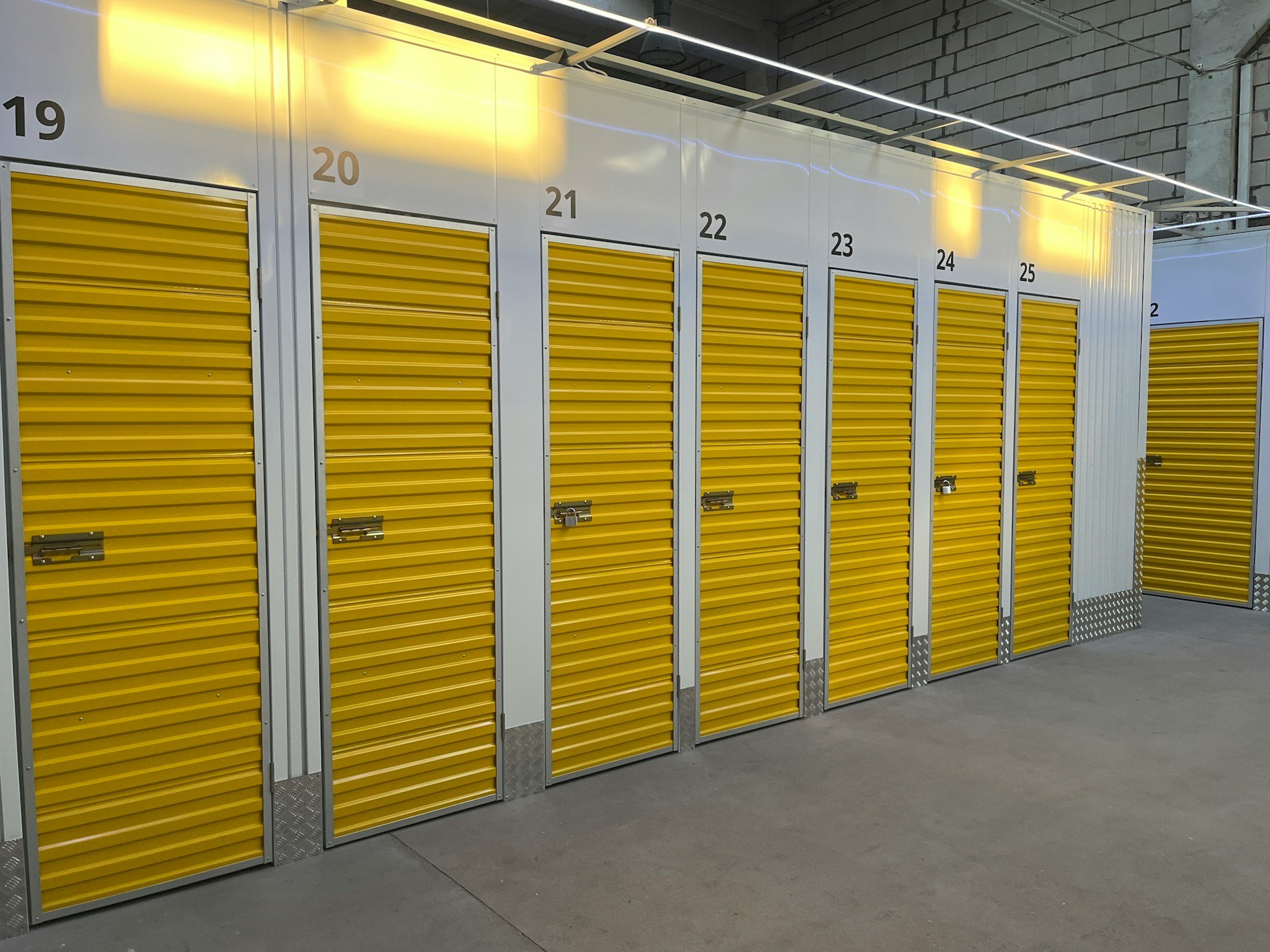Indoor self-storage facility featuring a row of numbered yellow units.